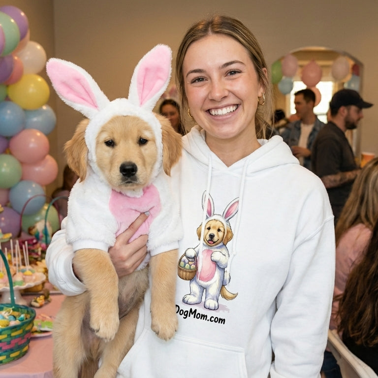 Person wearing a hoodie with a dog in bunny costume at a festive indoor event.