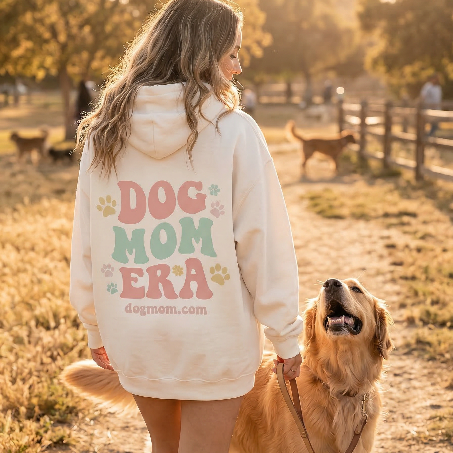 Dog Mom Era Hoodie - back view at dog park with golden retriever during golden hour - DogMom.com